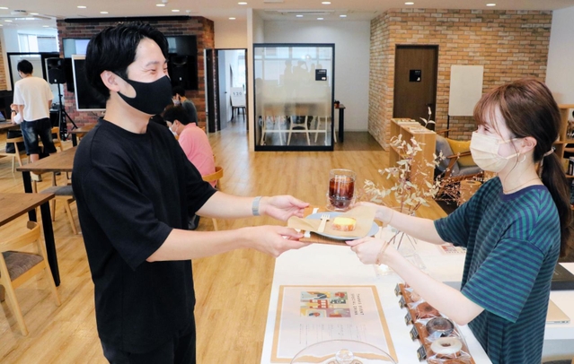 ３周年を記念し、無料で提供された菓子や飲料を受け取る利用者＝神戸市中央区磯上通４、１２０ＷＯＲＫＰＬＡＣＥ　ＫＯＢＥ