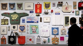 「ＯＳＡＭＵ　ＧＯＯＤＳ」がずらりと並ぶ展示空間＝神戸ファッション美術館（撮影・長嶺麻子）