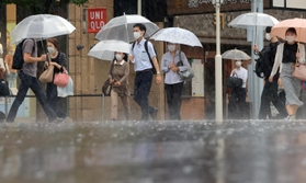 強い雨の中、傘を差して歩く人たち＝７日午前、神戸市中央区（撮影・吉田敦史）