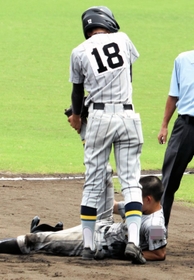 内野安打の力走で足がつった選手を救護するナイン＝高砂市、高砂球場（画像を一部加工しています）