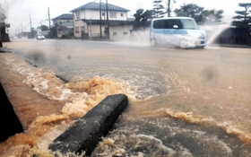 豪雨で排水溝からあふれた泥水が道路に流れ出た＝７日午後、宍粟市山崎町高所（撮影・村上晃宏）