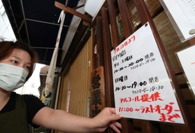 午前から開店する店では、酒類の提供時間などの変更を伝える紙が貼り替えられた＝１２日午前、神戸市中央区元町通１（撮影・長嶺麻子）