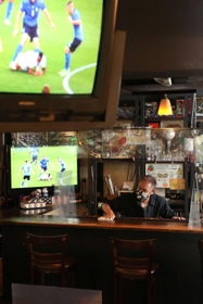 ３０分の時短緩和では「何も変わらない」と話すスポーツバーのオーナー。店内のモニターでサッカーの試合の録画映像を流しながら客を待った＝１２日午後、神戸市中央区（撮影・小林良多）