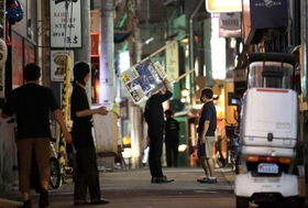 時短営業の緩和はわずか３０分。午後８時半に店の看板を片付ける飲食店関係者＝１２日夜、神戸市中央区中山手通１