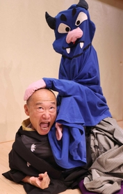 全身を駆使し、青色の妖怪に攻撃される三蔵法師を表現する笑福亭鶴笑さん＝神戸市兵庫区、神戸新開地・喜楽館（撮影・長嶺麻子）