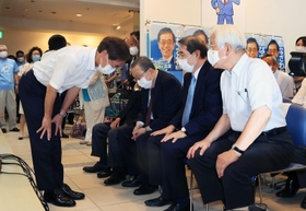 井戸敏三知事（右端）ら支援者に頭を下げる金沢和夫氏＝１８日午後８時２１分、神戸市中央区元町通１（撮影・鈴木雅之）