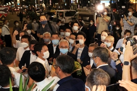 事務所に入りきれなかった大勢の支援者から祝福される斎藤元彦氏（左中）＝１８日午後８時２９分、神戸市中央区布引町３（撮影・吉田敦史）