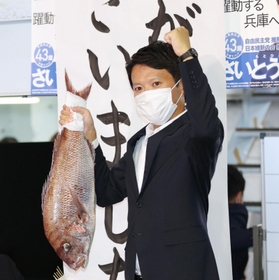 支持者から贈られた鯛を掲げる斎藤元彦氏＝１８日午後８時１２分、神戸市中央区布引町３（撮影・小林良多）