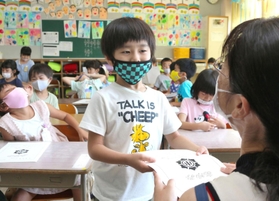 緊張した面持ちで初めての通知表を受け取る１年生＝２０日午前、三田市すずかけ台２