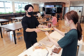 ３周年を記念し、無料で提供された菓子や飲料を受け取る利用者＝神戸市中央区磯上通４、１２０ＷＯＲＫＰＬＡＣＥ　ＫＯＢＥ