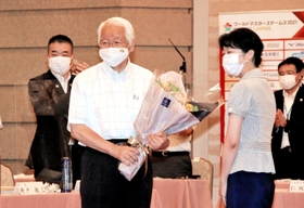 関西広域連合本部事務局の職員から花束を手渡され、笑顔を見せる井戸敏三知事（左から２人目）＝２９日午前、大阪市北区
