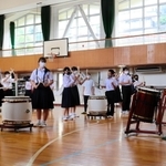 山中裕貴さん（右）の指導で和太鼓に触れる生徒ら＝神戸市中央区熊内町６、市立布引中学校