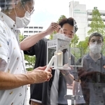 「１・１７希望の灯り」をろうそくに分灯する藤本真一代表理事（中央）ら＝５日午後、神戸市中央区加納町６（撮影・三津山朋彦）