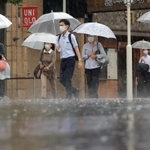 強い雨の中、傘を差して歩く人たち＝７日午前、神戸市中央区（撮影・吉田敦史）