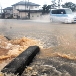豪雨で排水溝からあふれた泥水が道路に流れ出た＝７日午後、宍粟市山崎町高所（撮影・村上晃宏）