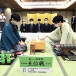 ７番勝負の第２局で初手を指す豊島将之竜王（右）。左は藤井聡太王位＝１３日午前、北海道旭川市、花月会館