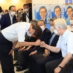井戸敏三知事（右）に頭を下げながらグータッチする金沢和夫氏＝１８日午後８時３２分、神戸市中央区元町通１（撮影・鈴木雅之）