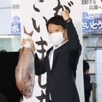 支持者から贈られた鯛を掲げる斎藤元彦氏＝１８日午後８時１２分、神戸市中央区布引町３（撮影・小林良多）