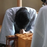 対局中、熟考する藤井聡太王位。右は豊島将之竜王＝２２日午後１時３２分、神戸市北区有馬町の「中の坊瑞苑」