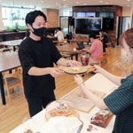 ３周年を記念し、無料で提供された菓子や飲料を受け取る利用者＝神戸市中央区磯上通４、１２０ＷＯＲＫＰＬＡＣＥ　ＫＯＢＥ