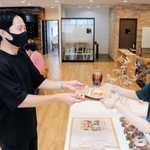 ３周年を記念し、無料で提供された菓子や飲料を受け取る利用者＝神戸市中央区磯上通４、１２０ＷＯＲＫＰＬＡＣＥ　ＫＯＢＥ