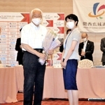 関西広域連合本部事務局の職員から花束を手渡され、笑顔を見せる井戸敏三知事（左から２人目）＝29日午前、大阪市北区