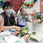 園芸療法士の助言を受けてフラワーアレンジメントに取り組む高齢者＝東京都荒川区、介護老人保健施設「ひぐらしの里」