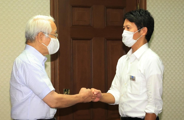 事務引き継ぎ式で井戸敏三前知事（左）とグータッチを交わす斎藤元彦知事＝２日午後、県公館