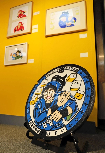 リハビリ後の作品を飾るコーナーでは、久々知兵助をあしらったマンホールも登場。原画は２０２１年に描いた＝尼崎市昭和通２、尼崎市総合文化センター