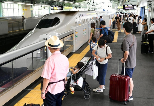 お盆の帰省シーズンを迎え、新幹線の到着を待つ人たち＝７日午前、神戸市中央区加納町１、ＪＲ新神戸駅（撮影・坂井萌香）