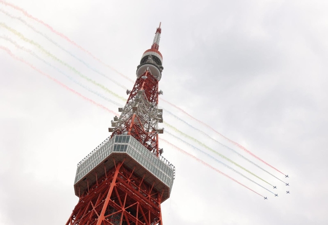 鮮やかなスモークで航跡を残して飛行するブルーインパルス＝２４日午後２時８分、東京都港区芝公園４（撮影・吉田敦史）