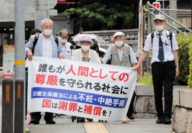横断幕を手に神戸地裁に入場する強制不妊訴訟の原告団たち＝３日午後０時４８分、神戸市中央区橘通２