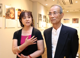 神戸市内で開かれた原爆を伝える写真展で、父親の吉田幸一さん（右）と語る高奈生美さん＝神戸市中央区東川崎町１（撮影・長嶺麻子）