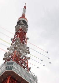 鮮やかなスモークで航跡を残して飛行するブルーインパルス＝２４日午後２時８分、東京都港区芝公園４（撮影・吉田敦史）