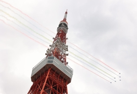 鮮やかなスモークで航跡を残して飛行するブルーインパルス＝２４日午後２時８分、東京都港区芝公園４（撮影・吉田敦史）