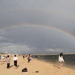 突然の雨とともに砂浜の向こうに架かった巨大な二重の虹＝６日午後、神戸市須磨区須磨浦通４（撮影・小林良多）