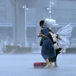 強い風と雨で、傘がひっくり返った女性たち。台風９号の影響で、神戸市にも暴風・波浪警報が出され、断続的に風雨が強まった＝９日午前１１時３４分、神戸市中央区波止場町（撮影・鈴木雅之）