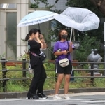 強い風にあおられる人たち＝９日午前１１時５３分、神戸市中央区東川崎町１（撮影・吉田敦史）