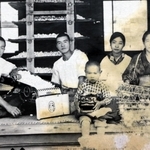 中国で戦没した父親の輝治さん（左から２人目）らと撮った家族の写真。幼い頃の柿原啓志さん（中央）は父がお土産でくれた獅子舞の頭を持つ（柿原さん提供）