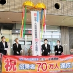 ７０万人達成を祝い、くす玉を割る関係者たち＝豊岡市岩井