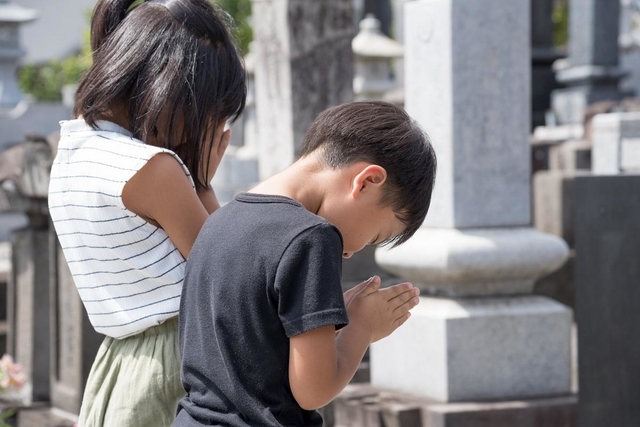 お墓参りする子ども（資料写真、tatsushi/stock.adobe.com）