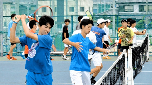 素振りをする相生学院高校テニス部の選手。南颯汰選手（左）らは米国の大学進学を目指す＝加古川市神野町石守、トップランテニスカレッジ加古川石守校