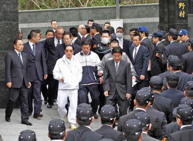 工藤会関係先を家宅捜索する福岡県警捜査員と野村悟被告（中央左、白色の服装）