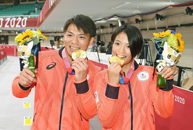 東京五輪の柔道で兄妹そろって優勝し、金メダルを口に当てる阿部一二三（左）と阿部詩＝７月２５日、東京・日本武道館