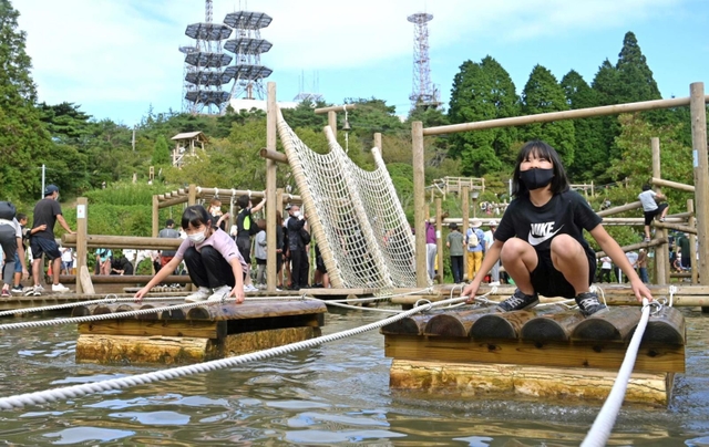 水上アスレチックを楽しむ子どもら＝１９日午後、神戸市灘区六甲山町、グリーニア（撮影・秋山亮太）