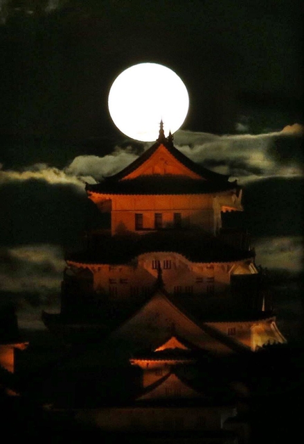 夜空に浮かぶ中秋の名月と、オレンジ色に染まる姫路城大天守＝２１日午後７時２分、姫路市岡町から望む