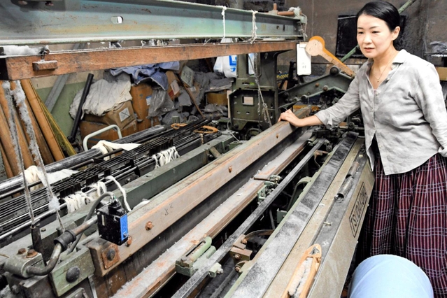 旧式の織り機を見る大塚美智代さん＝西脇市中畑町