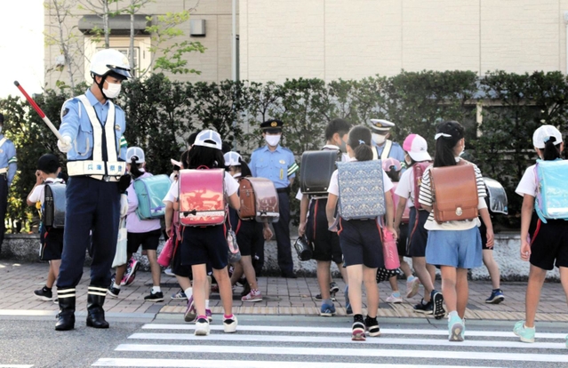 横断歩道で児童を見守る垂水署員＝神戸市垂水区舞多聞西５