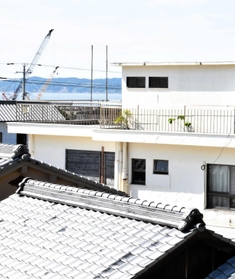 ９月末で閉園する「ぬしま保育園」（白い建物）。海を挟んで対岸の淡路島“本土”を望む＝南あわじ市沼島