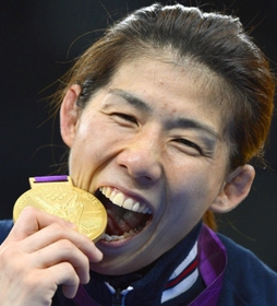 ロンドン五輪のレスリング女子で３連覇し、金メダルにかぶりつくように口を開ける吉田沙保里＝２０１２年８月、英国・エクセル